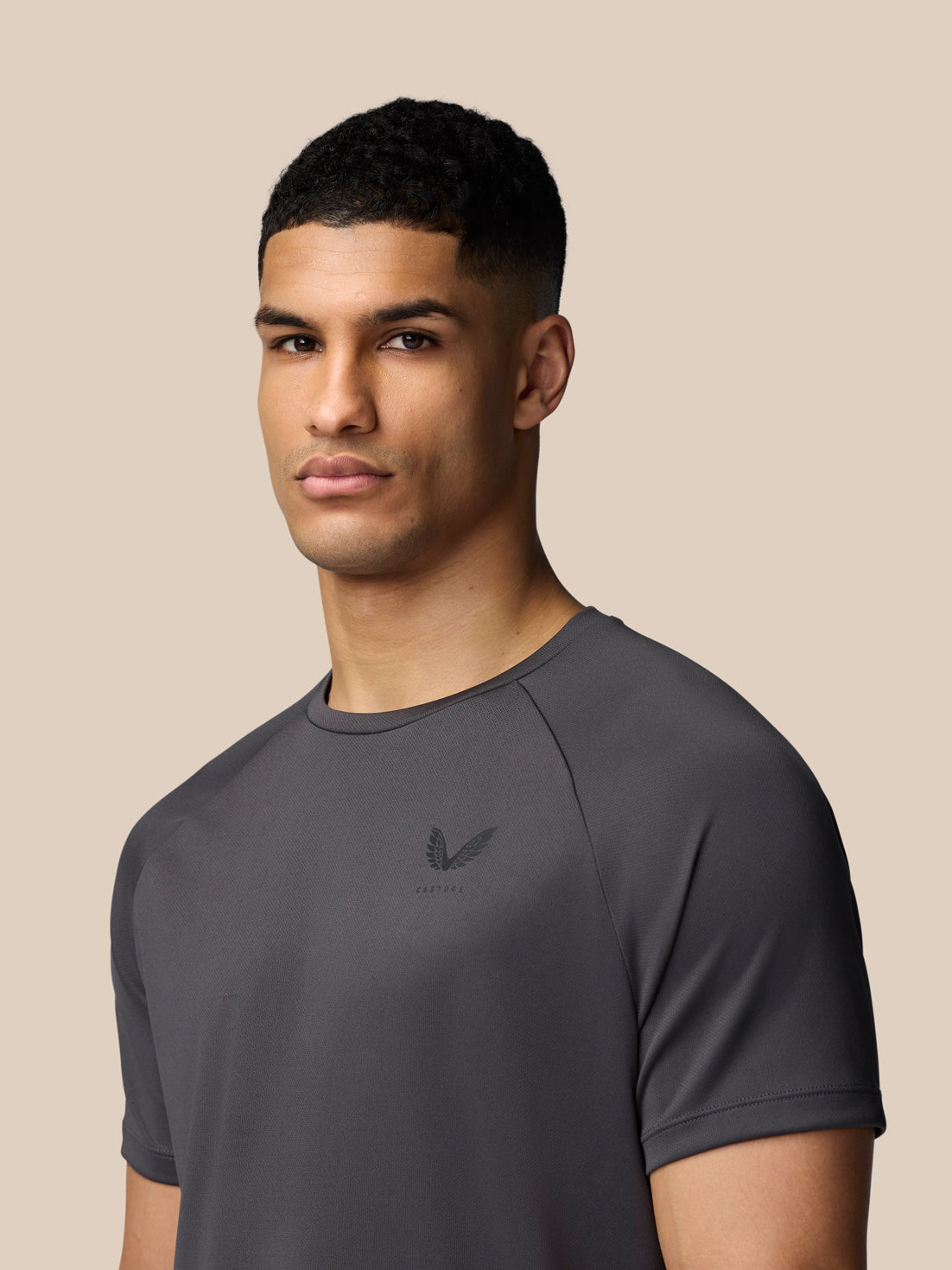 Three-quarter front view of a man in gunmetal Adapt Short Sleeve T-Shirt with Castore logo on the chest