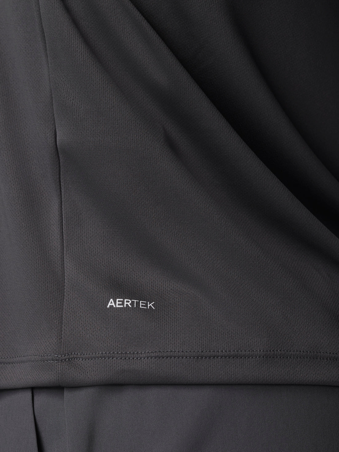 Close-up of gunmetal fabric with AERTEK branding and seam details