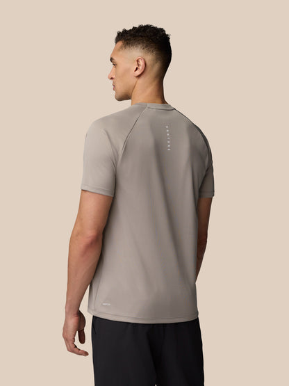 Back view of male model in light grey Adapt Training T-Shirt with vertical Castore branding along the upper back