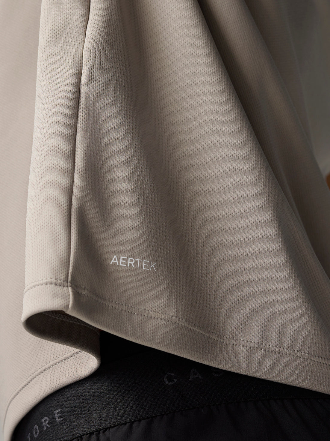 Close up of beige fabric at the sleeve with AERTEK branding on the Adapt Training T-Shirt