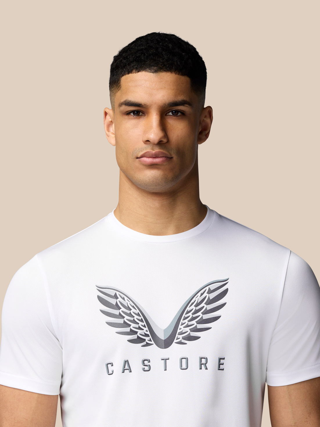 Close up of white graphic training T-shirt with wings logo on chest worn by model