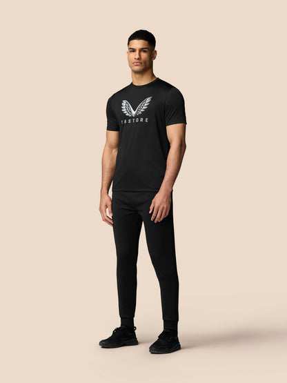 Front view of a man wearing a black short sleeve graphic training T shirt with Castore wings logo on the chest