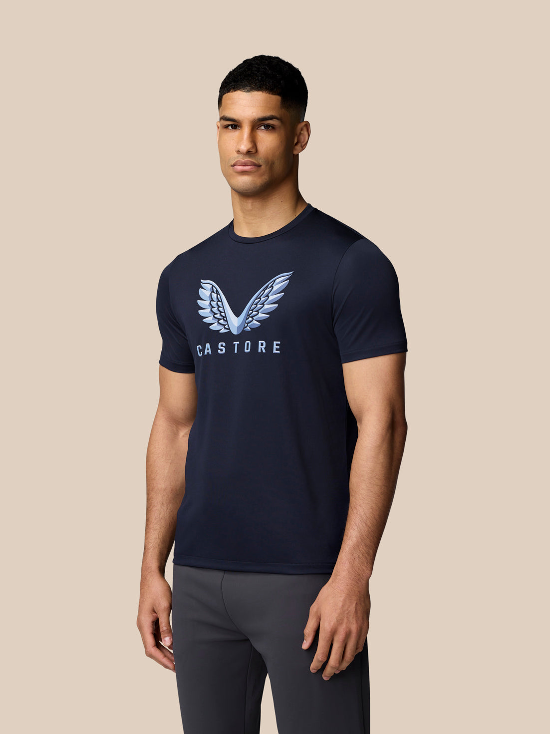 Back view of male model wearing navy graphic training T shirt showing clean back silhouette.