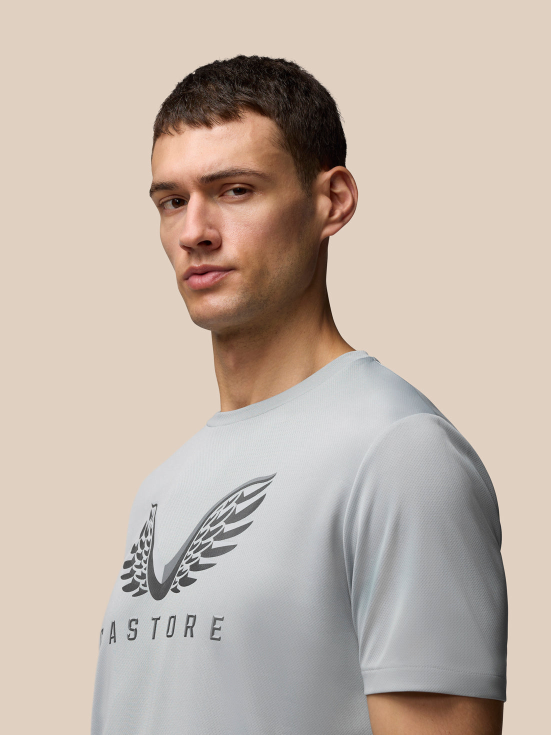 Male model wearing Adapt Graphic Training T-Shirt in grey white with Castore wings logo on chest