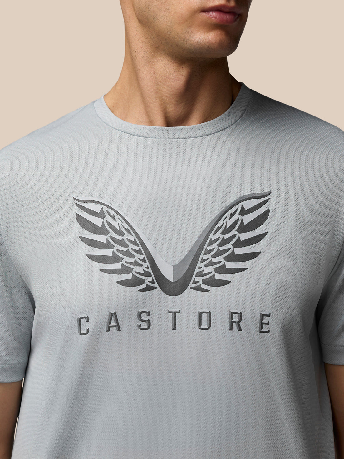 Close up of the grey Adapt Graphic Training T-Shirt chest showing the large wing logo and CASTORE lettering.