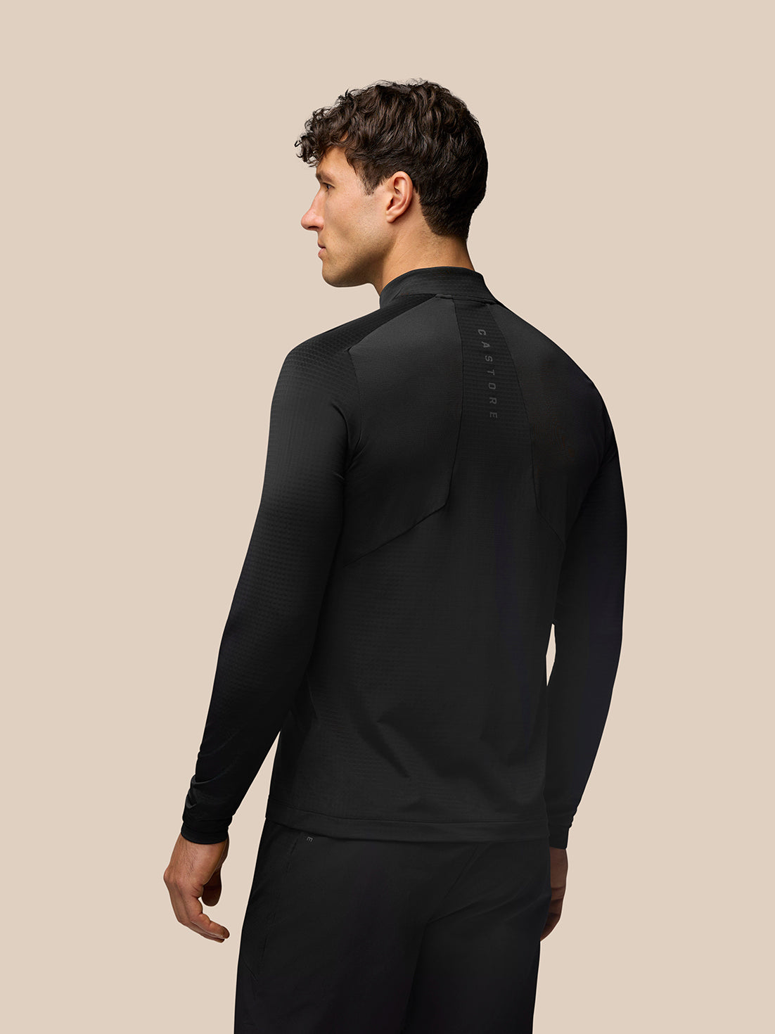 Back view of black Apex Training top with vertical branding along the spine