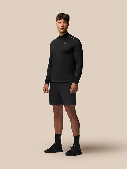 Male model wearing black Apex Training long sleeve top with shorts, showcasing athletic fit.