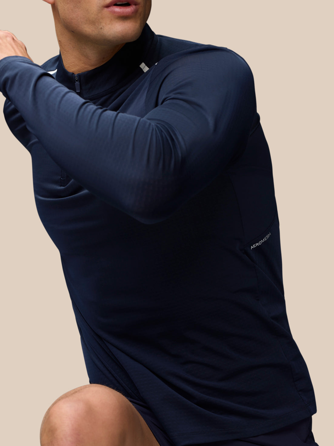 Navy Apex Training top in motion with subtle textured fabric and Aeromesh label visible at the side