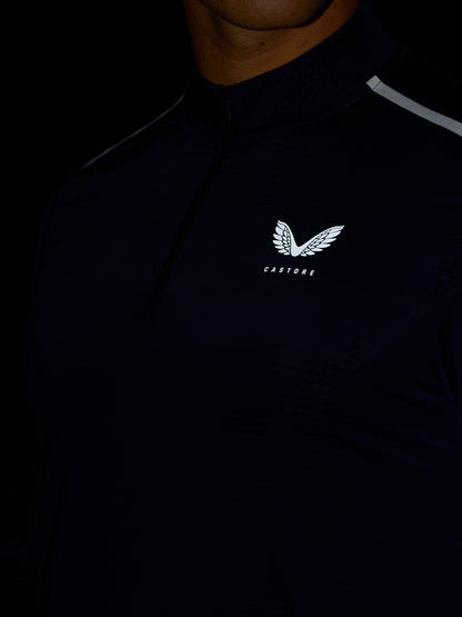 Close up of midnight navy Apex training top with quarter zip and Castore logo on chest.