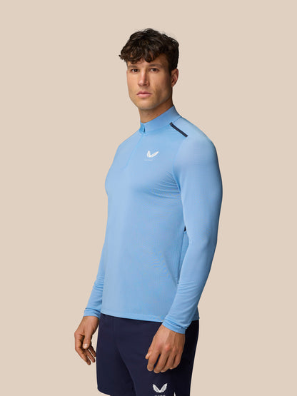 Side profile of a man wearing a sky blue Apex Training top with long sleeves and navy shorts