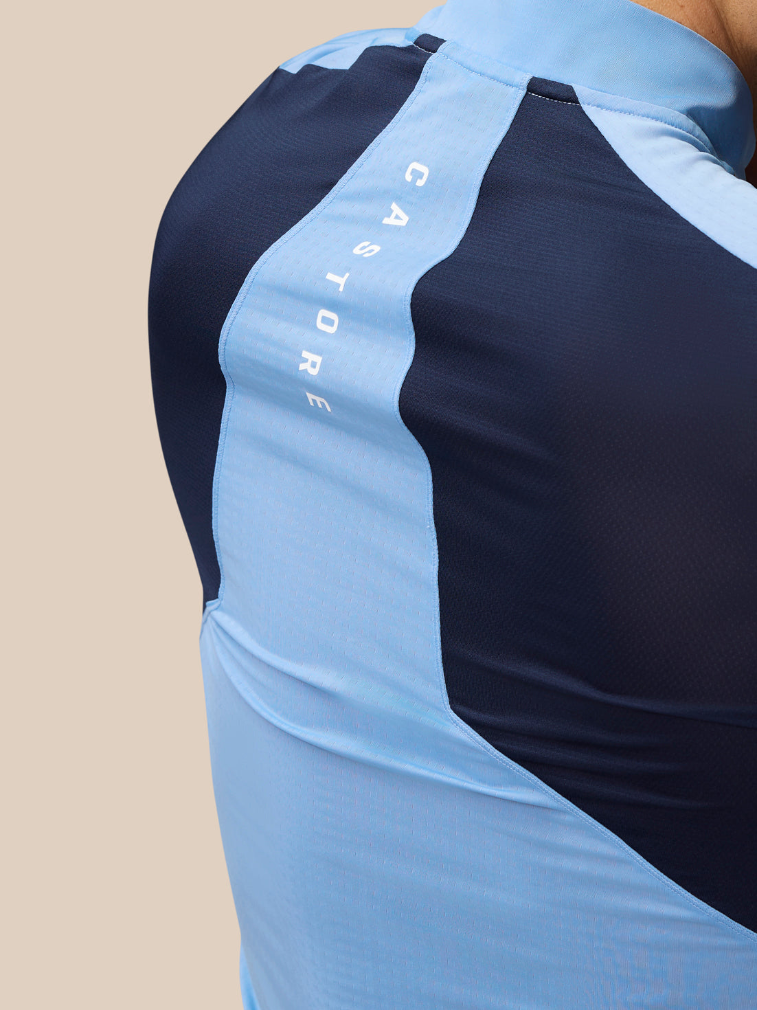 Back view of sky blue Apex Training top with navy side panels and light blue center stripe