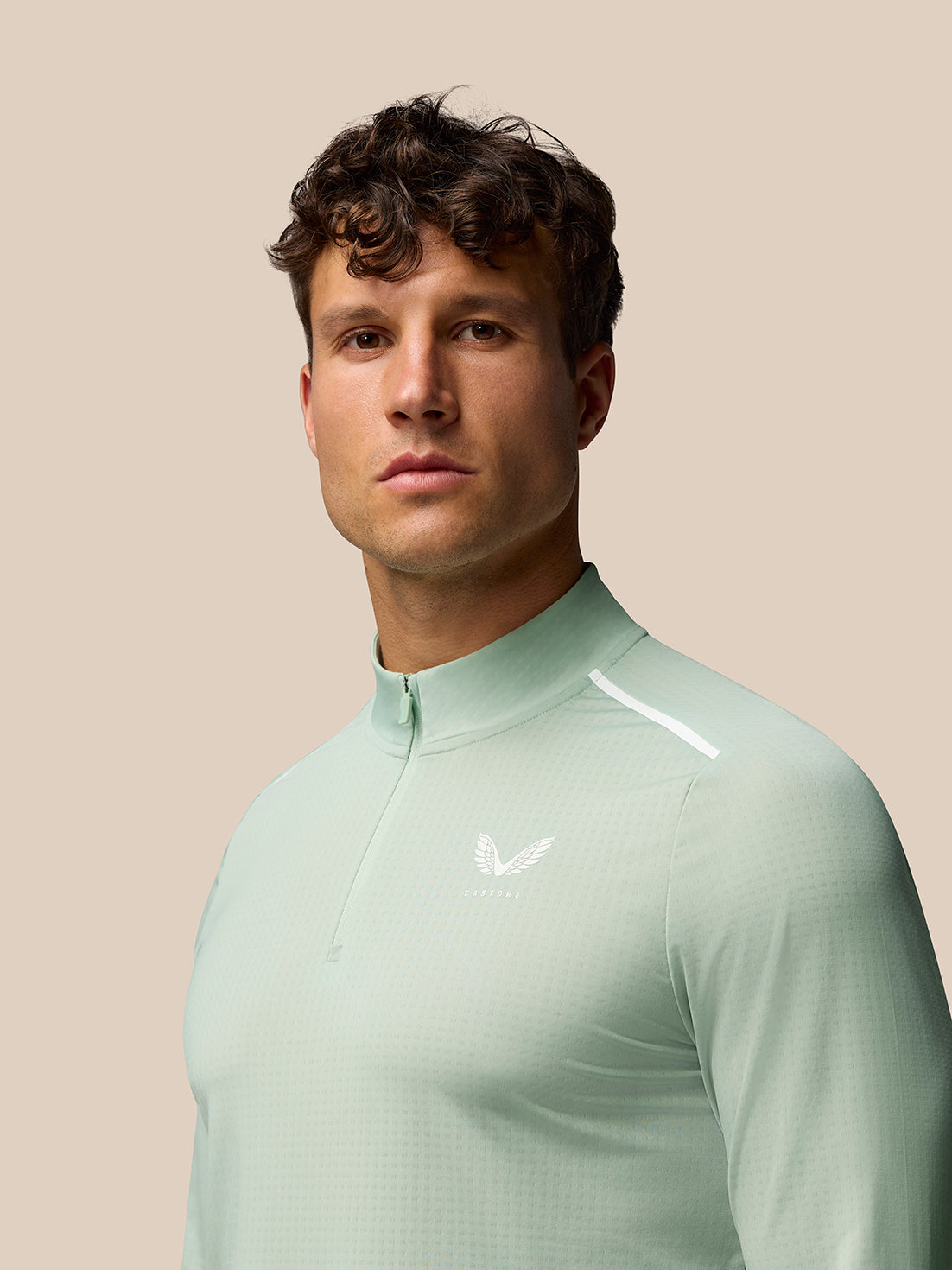 Male model wearing mint green Apex Aeromesh long sleeve quarter zip top with subtle white logo