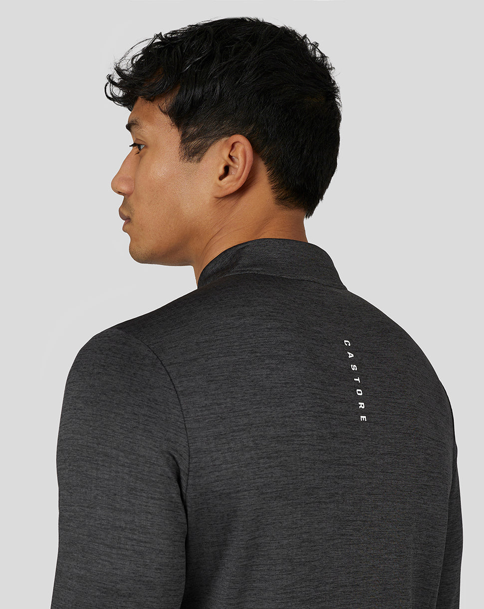 Model from behind in a dark marl long sleeve top with vertical Castore branding on the back