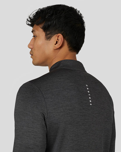 Model from behind in a dark marl long sleeve top with vertical Castore branding on the back