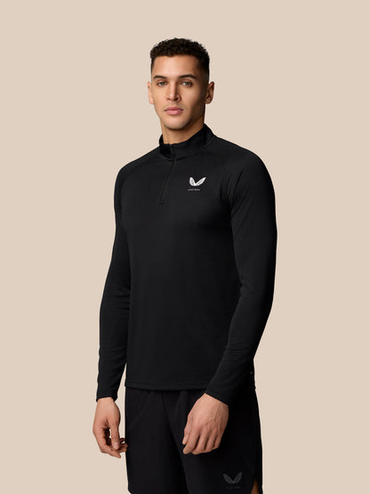 Male model wearing black Adapt Training 1/4 Zip Top with white Castore logo on chest