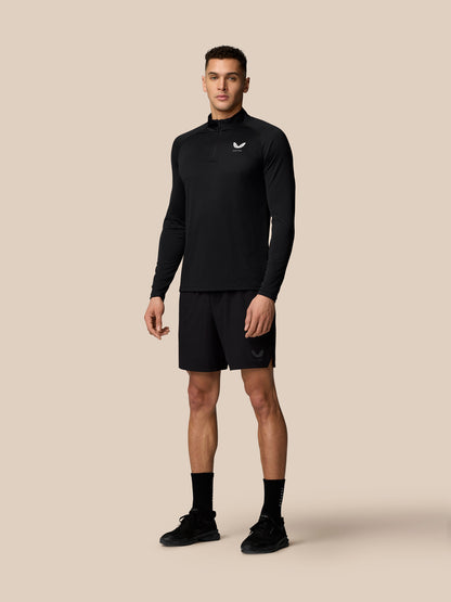 Male model wearing black Adapt Training 1/4 Zip top with matching shorts for a full athletic look