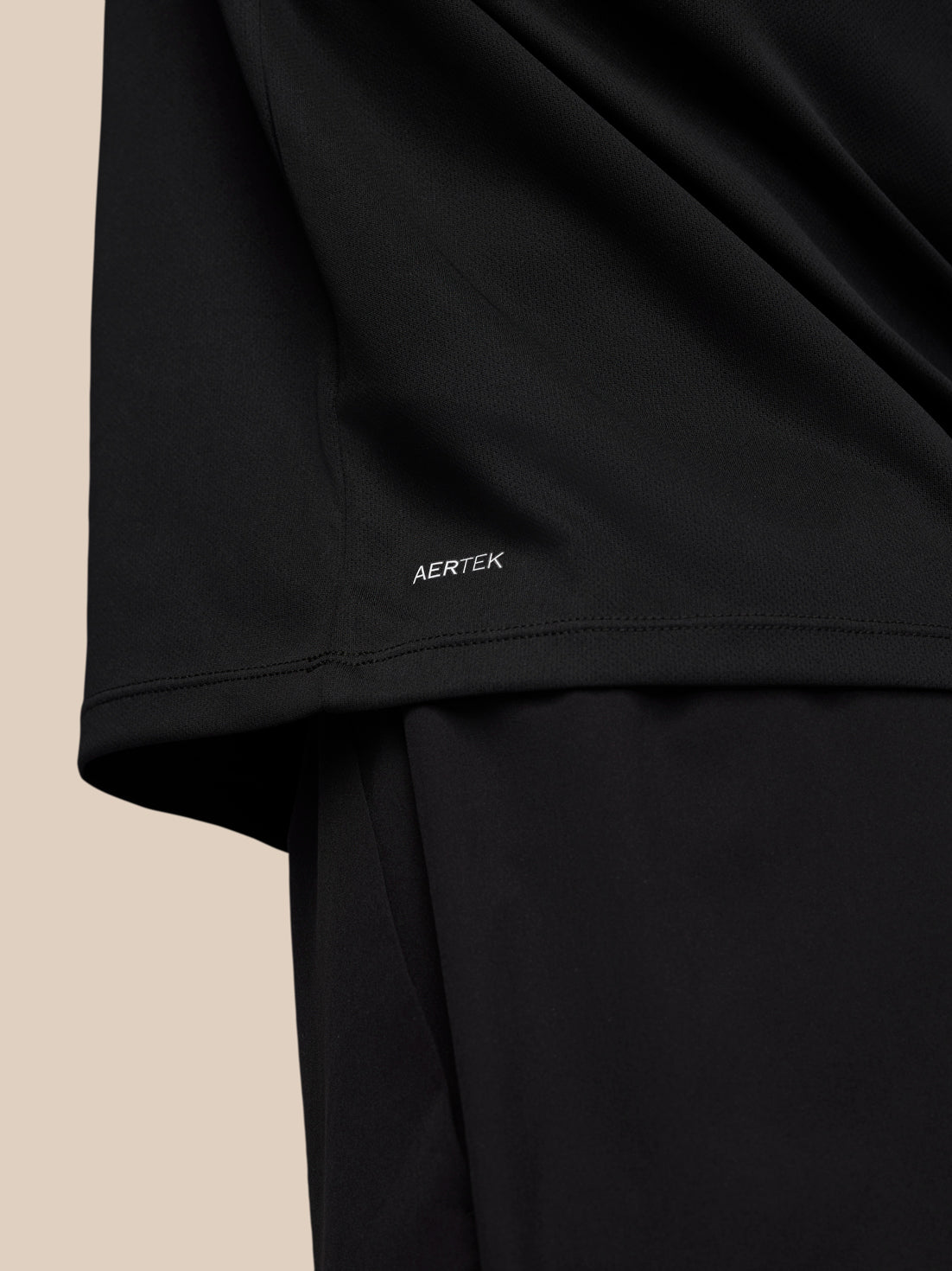 Close-up of the black Adapt Training top hem with AERTEK branding