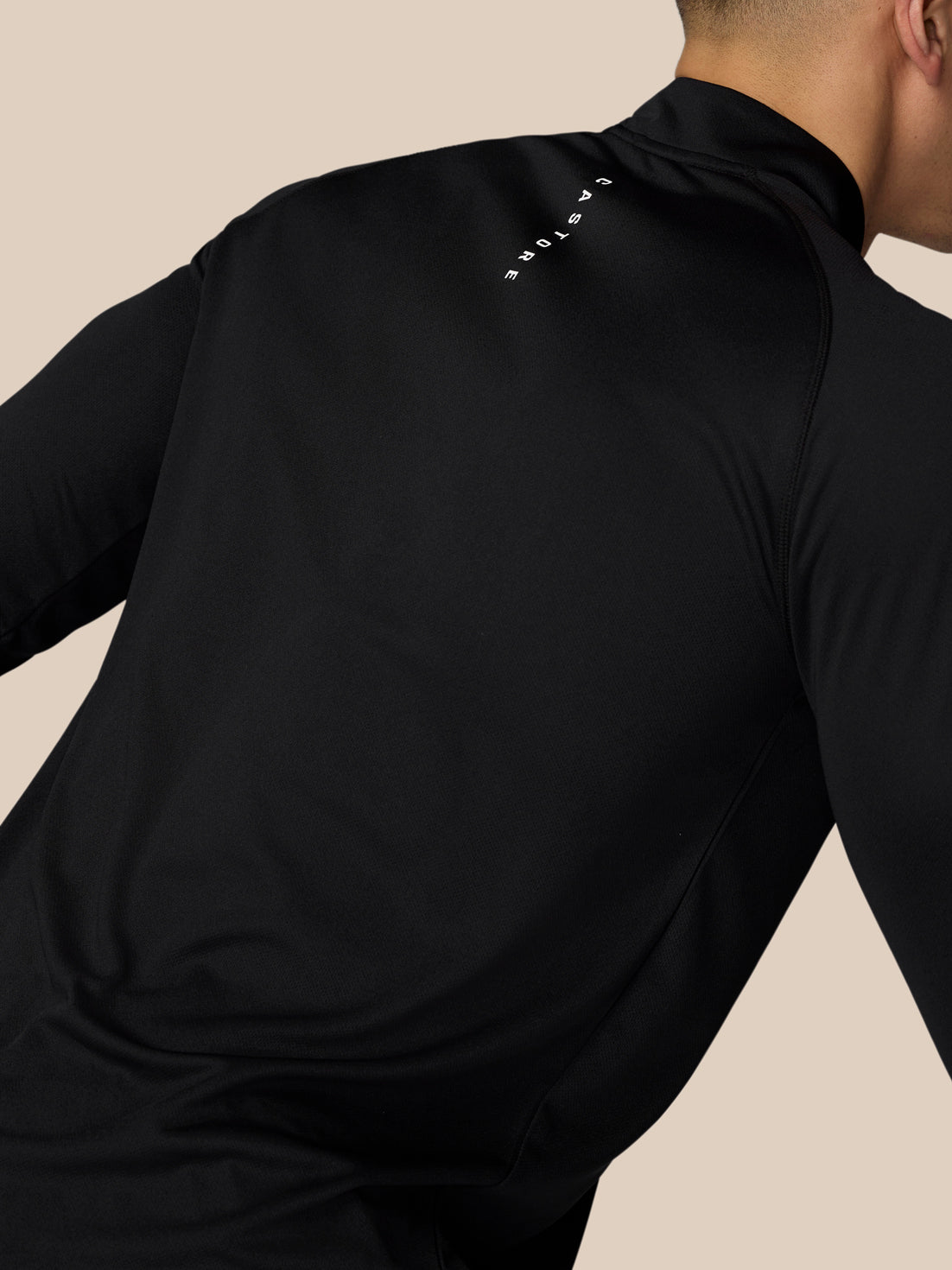 Back view of a man in black Adapt Training top with reflective branding on the back near the neck