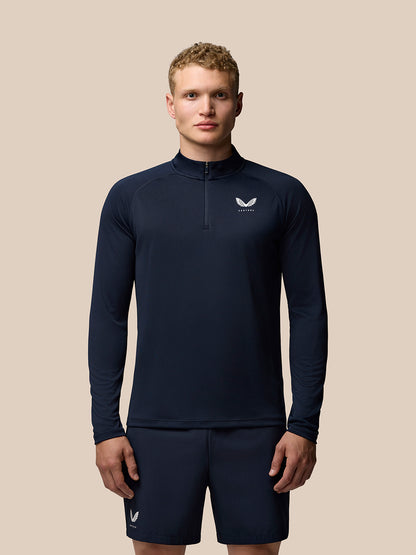 Male model wearing navy Adapt Training 1/4 Zip Top with stand collar and chest logo