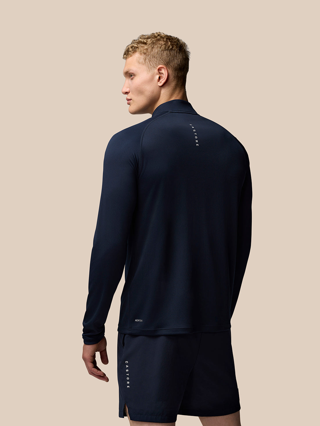 Rear view of navy Adapt Training top showing Castore branding down the upper back and Aertek branding at the lower back