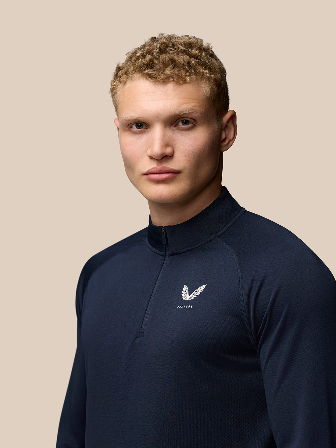 Front view of navy Adapt Training 1/4 Zip Top with stand collar and small Castore logo on the left chest