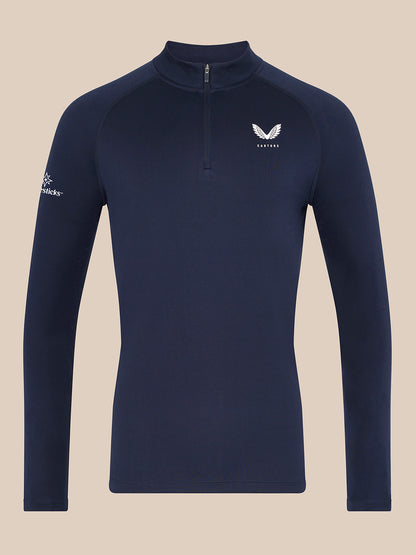 Man wearing navy Majesticks 1/4 Zip Top with stand collar and raglan sleeves, small Castore logo on chest.