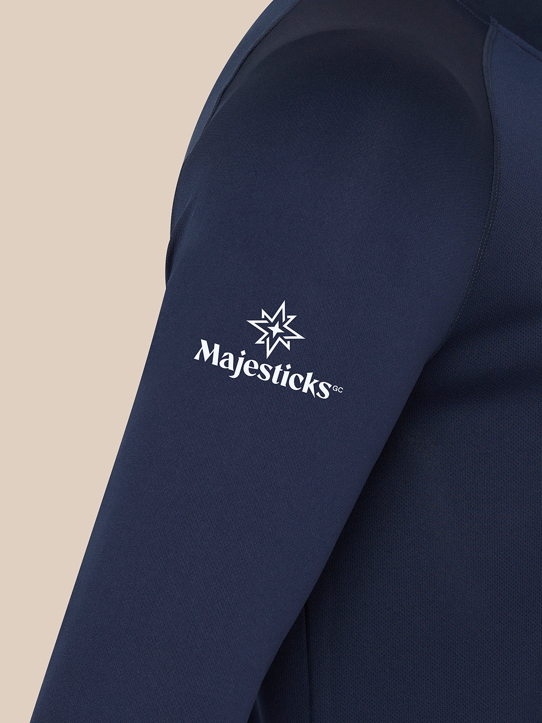 Close-up of navy Majesticks golf top sleeve displaying white Majesticks star and wordmark