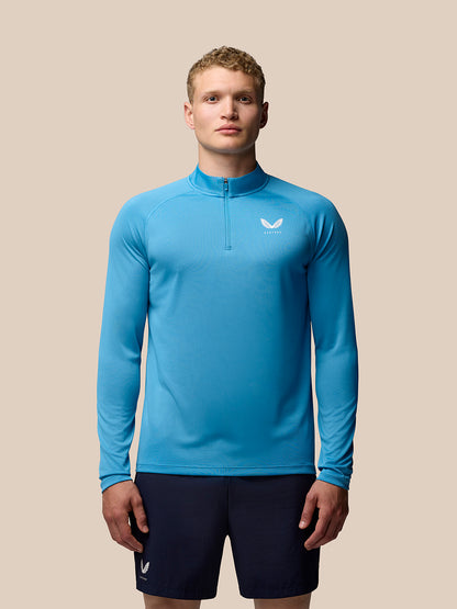 Front view of a man wearing corn blue Adapt Training 1/4 Zip Top with stand collar and left chest Castore logo