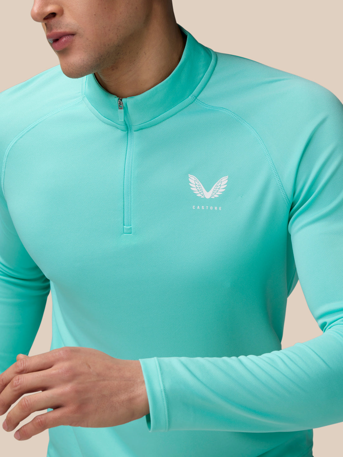 Close-up of light aqua Adapt Training 1/4 Zip Top front with quarter zip and Castore logo on left chest
