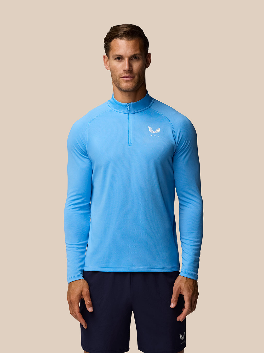 Male model in blue Adapt Training 1/4 Zip Top with logo on chest.