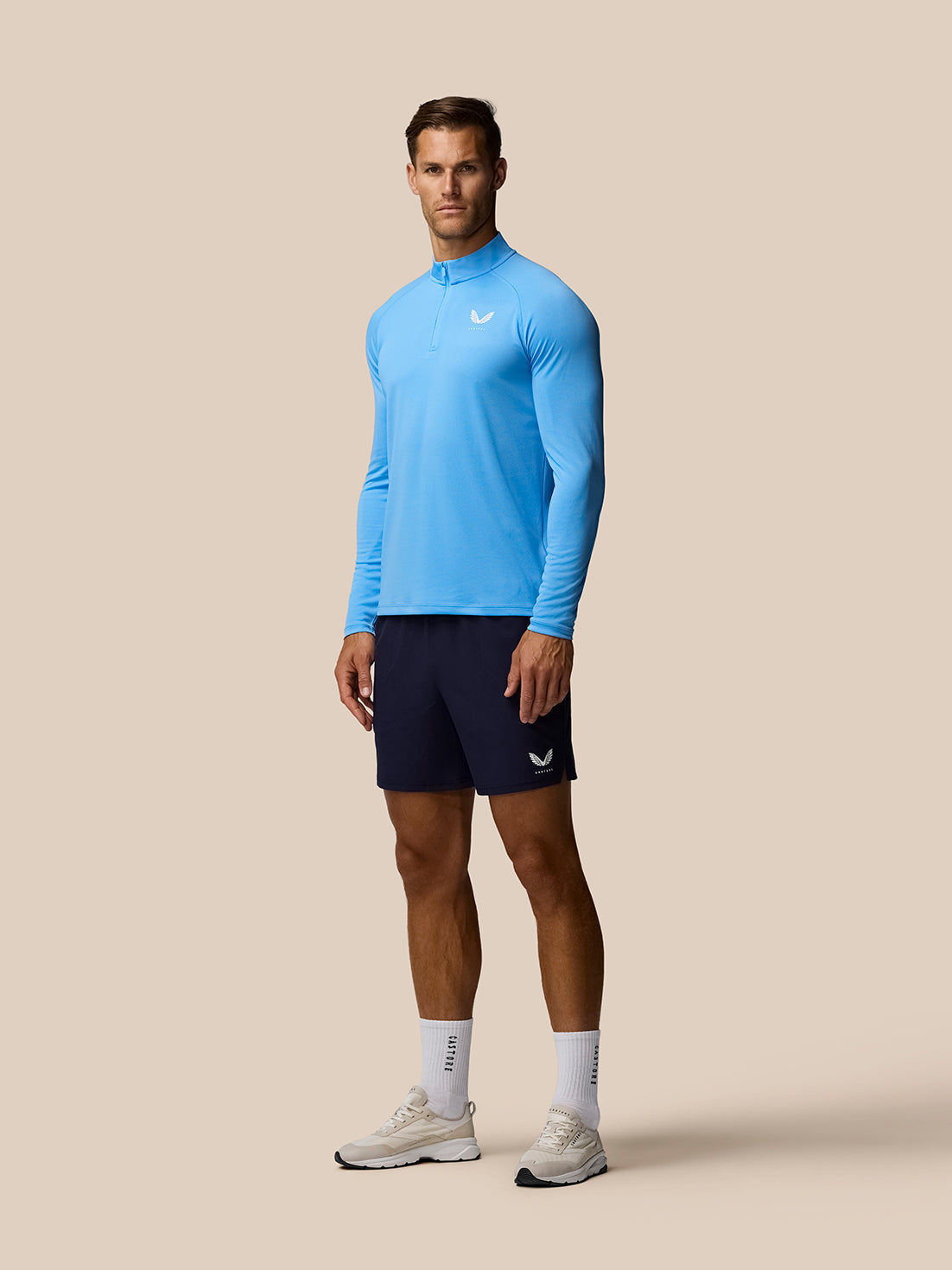 Male model wearing light blue Adapt Training 1/4 Zip Top with front quarter zip and raglan sleeves