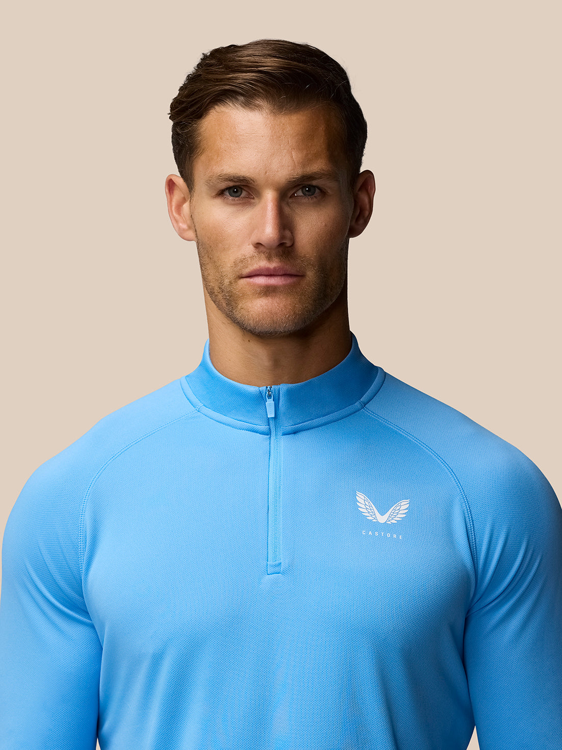 Close-up of the blue Adapt Training 1/4 Zip Top front with zip at the neckline and Castore logo on the left chest