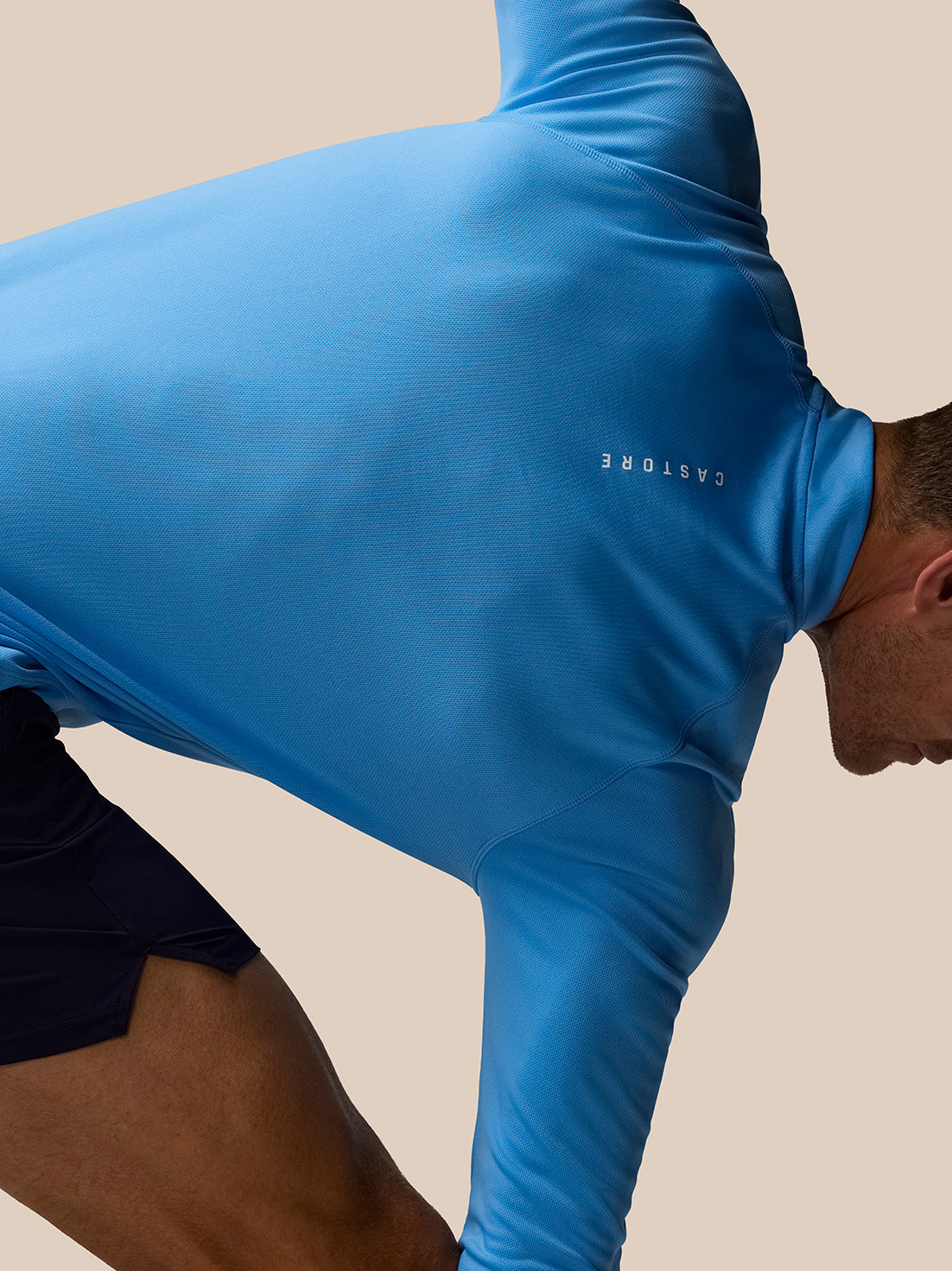 Back view of blue Adapt Training top on a person, showcasing AerTek fabric.