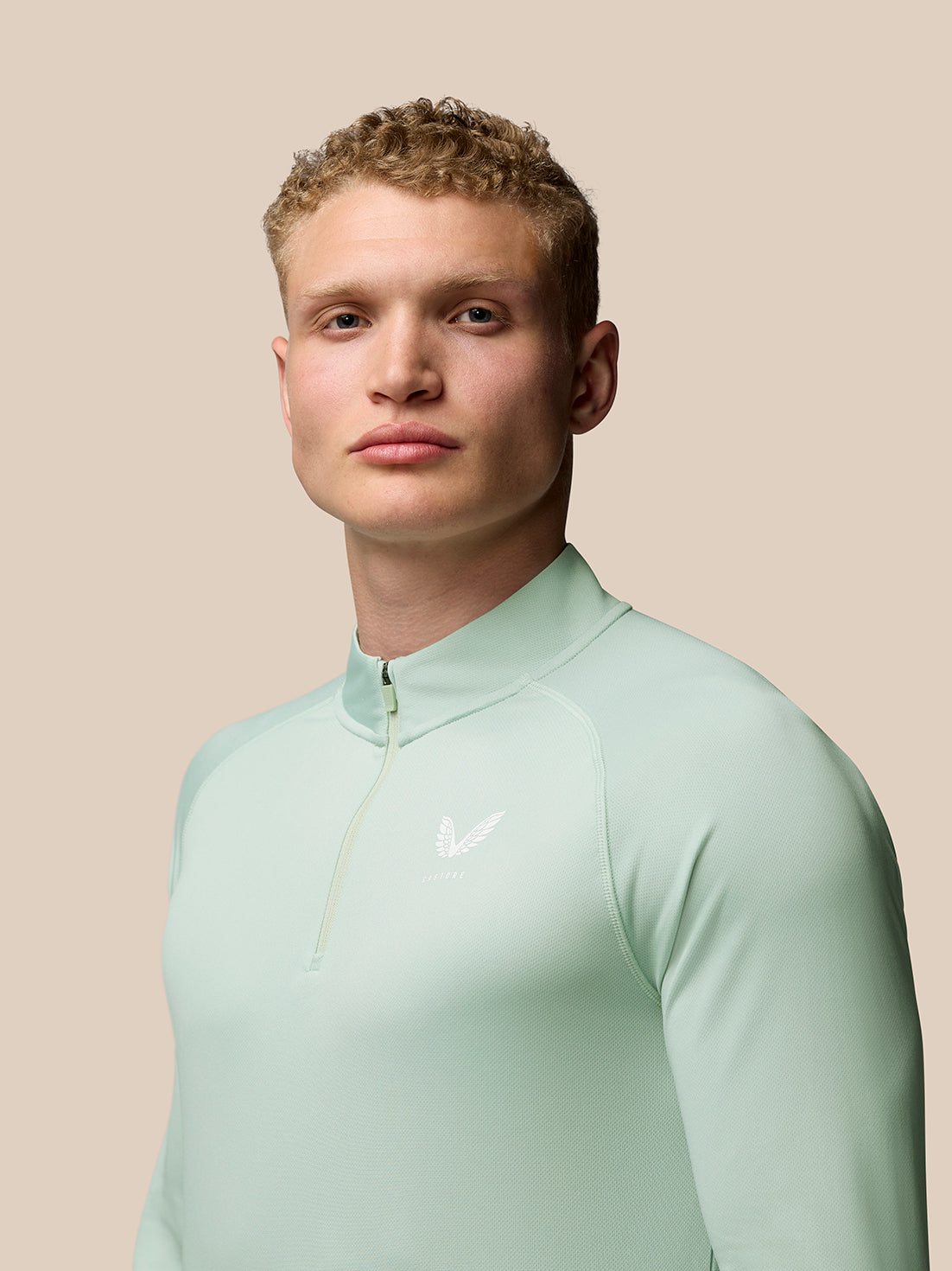 Mint green Adapt Training 1/4 Zip Top front view with stand collar and quarter zip, Castore branding at the chest