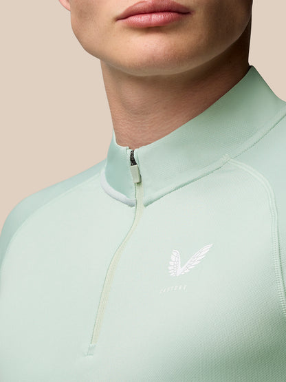 Close-up of the back of the mint green quarter zip top with vertical Castore branding