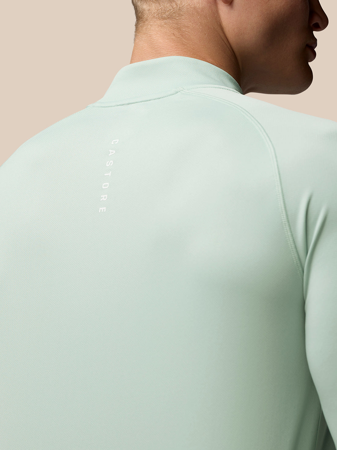 Back view of mint green Adapt Training top highlighting Castore branding along upper back