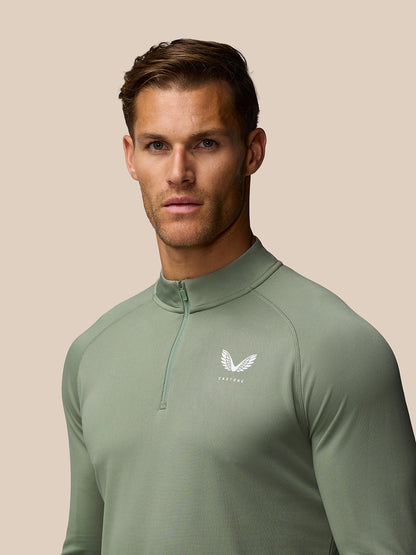 Close-up of a man in Thyme Mint Adapt Training 1/4 Zip with zip collar and left chest Castore logo