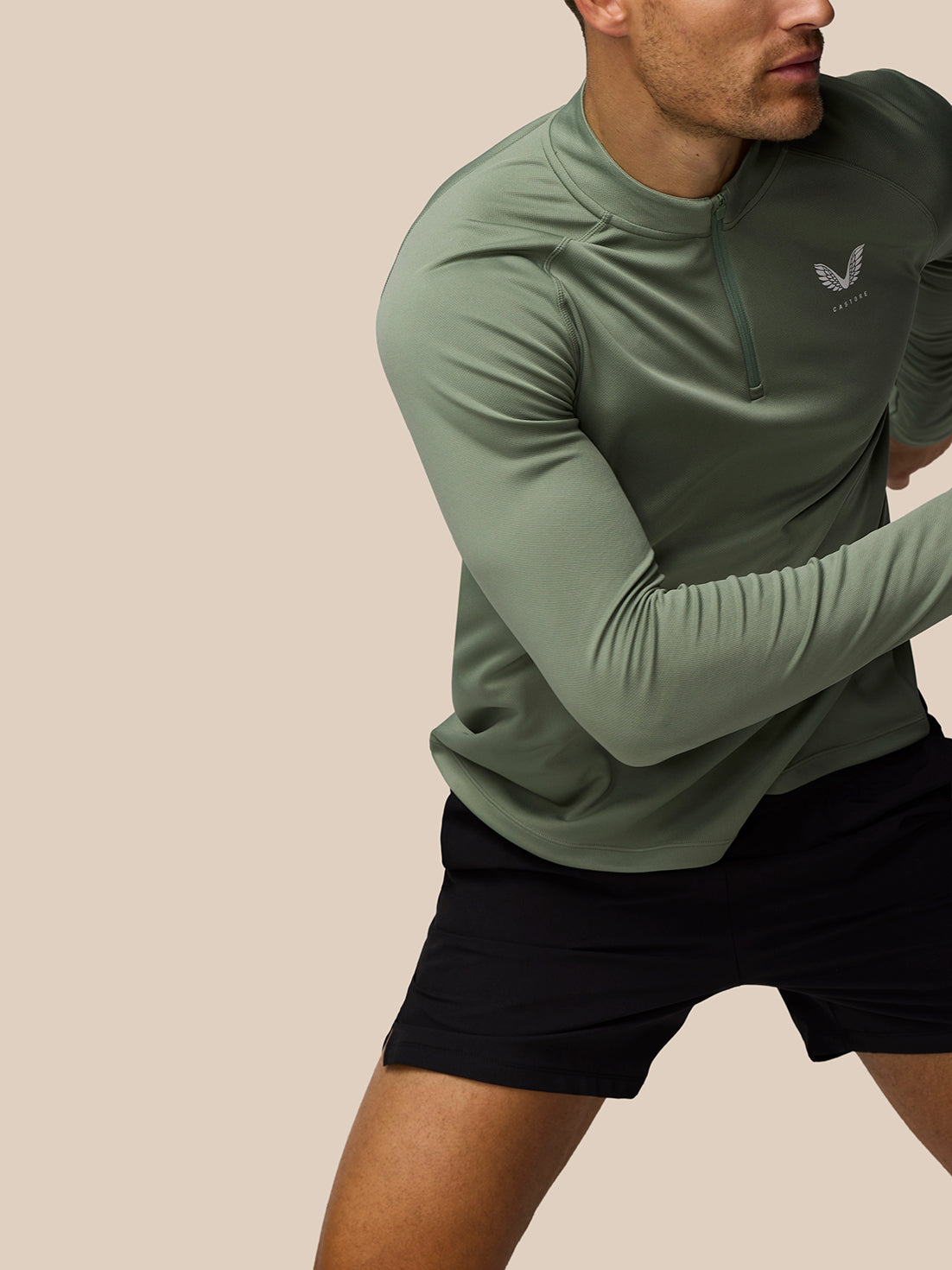 Male model wearing Thyme Mint Adapt Training 1/4 Zip top in motion showing raglan sleeves and front zip