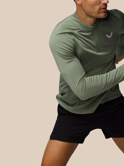 Male model wearing Thyme Mint Adapt Training 1/4 Zip top in motion showing raglan sleeves and front zip