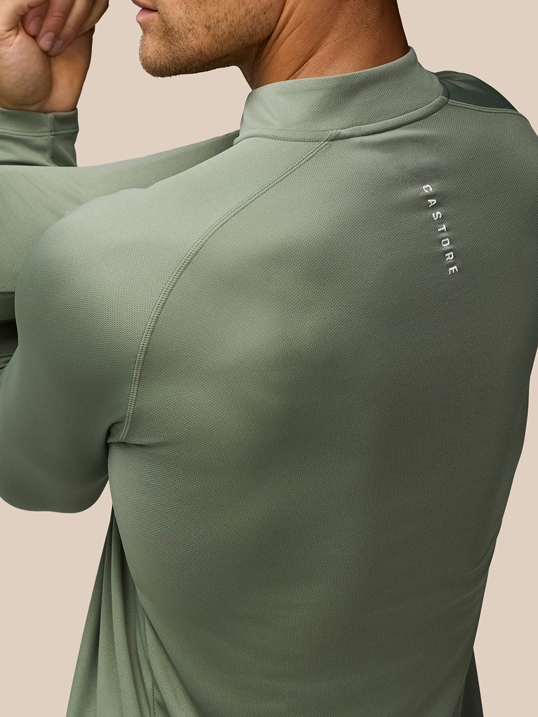 Close-up of the back shoulder area on the Thyme Mint Adapt Training top, showing textured fabric and the Castore logo.