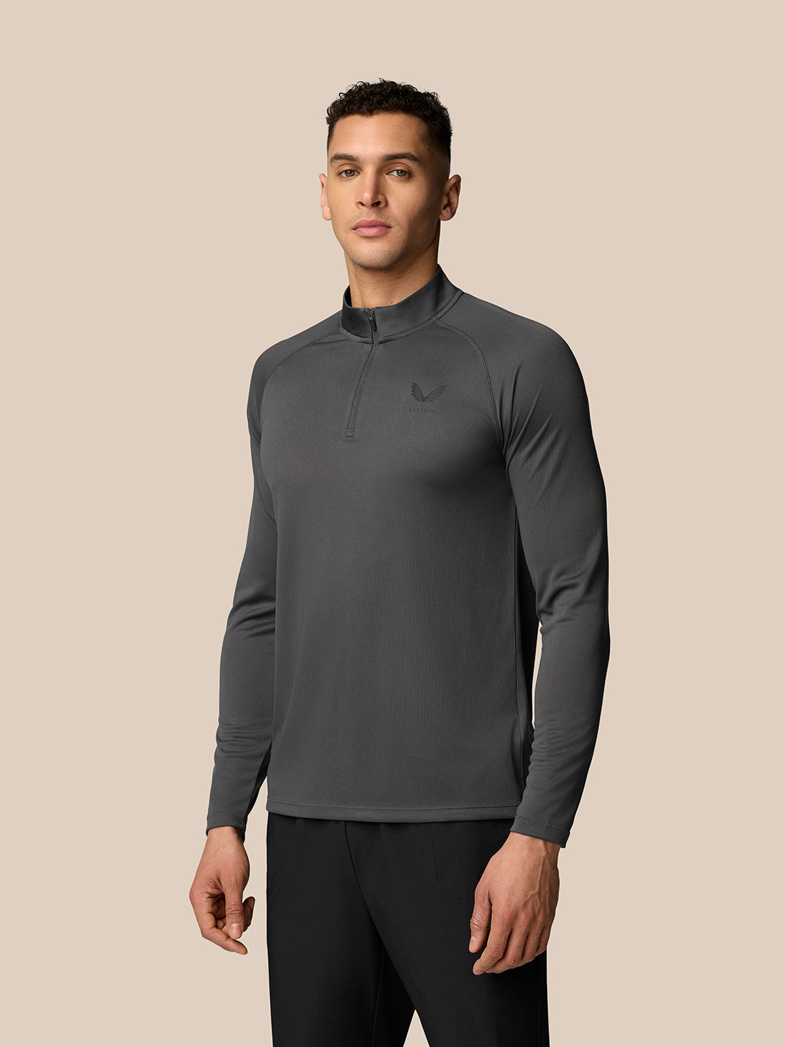 Male model wearing gunmetal Adapt Training quarter zip top with high collar and left chest logo