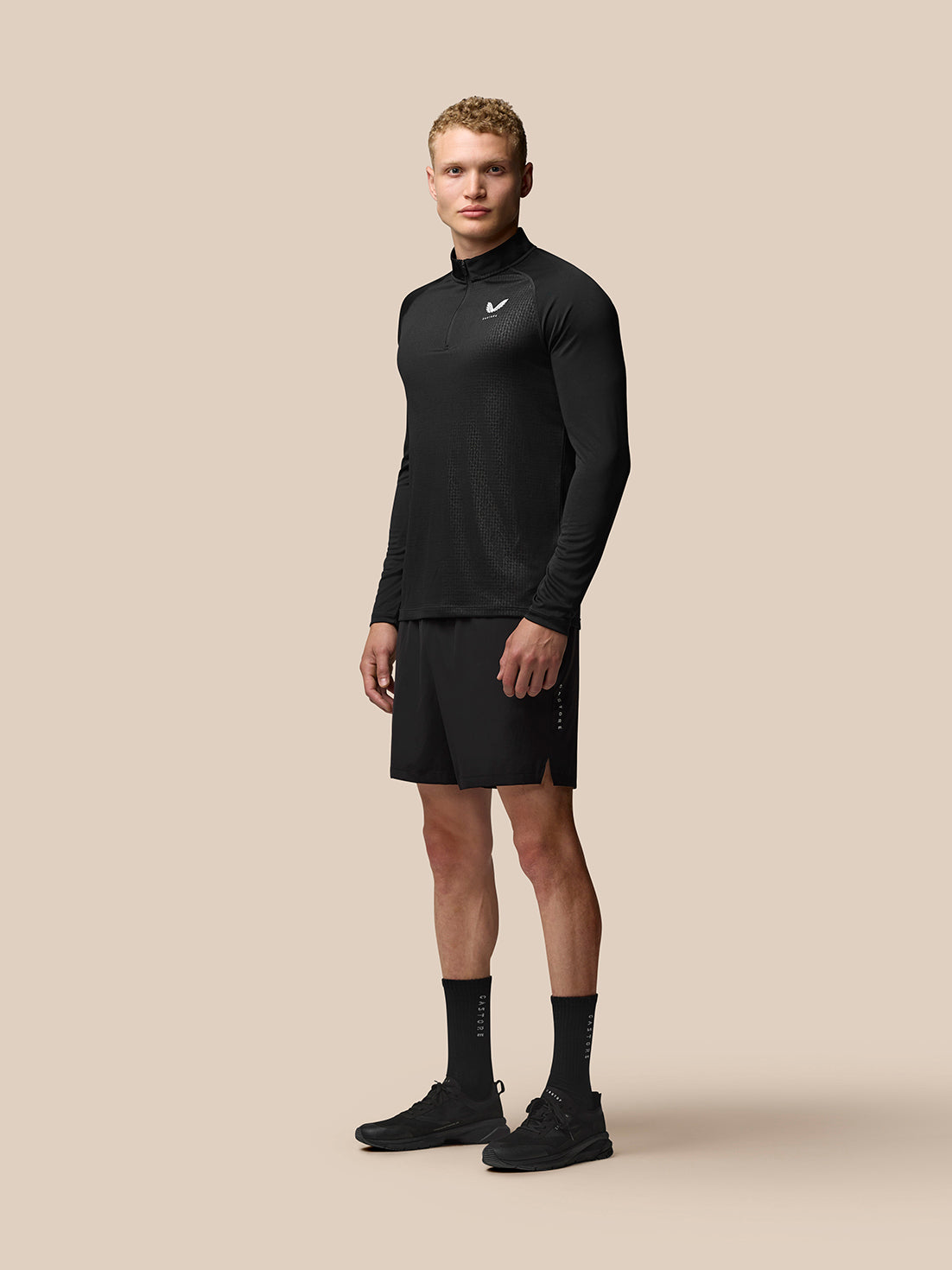 Man wearing black Adapt Training 1/4 Zip Top with stand collar and textured geometric pattern