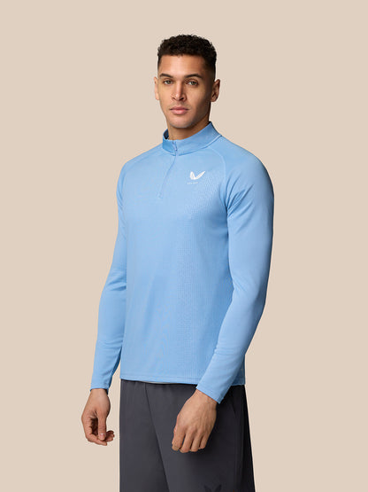 Model wearing sky blue Adapt Training 1/4 Zip Top with quarter zip and chest logo.