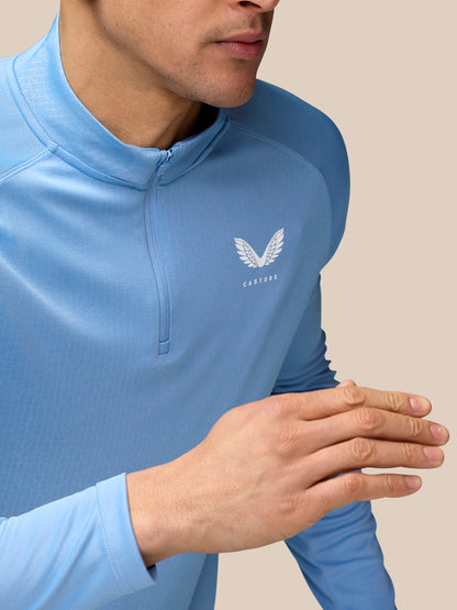 Front view of sky blue Adapt Training 1/4 Zip Top with left chest Castore logo and subtle all over print.