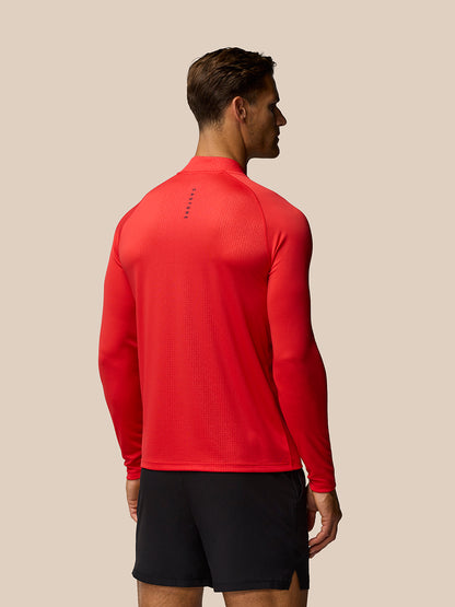 Back view of model in red Adapt Training 1/4 Zip Top, Castore branding on upper back and an all over print.