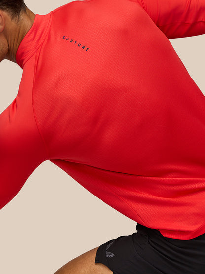 Close up of red Adapt Training 1/4 Zip Top showing Castore branding on the back and fine textured pattern.