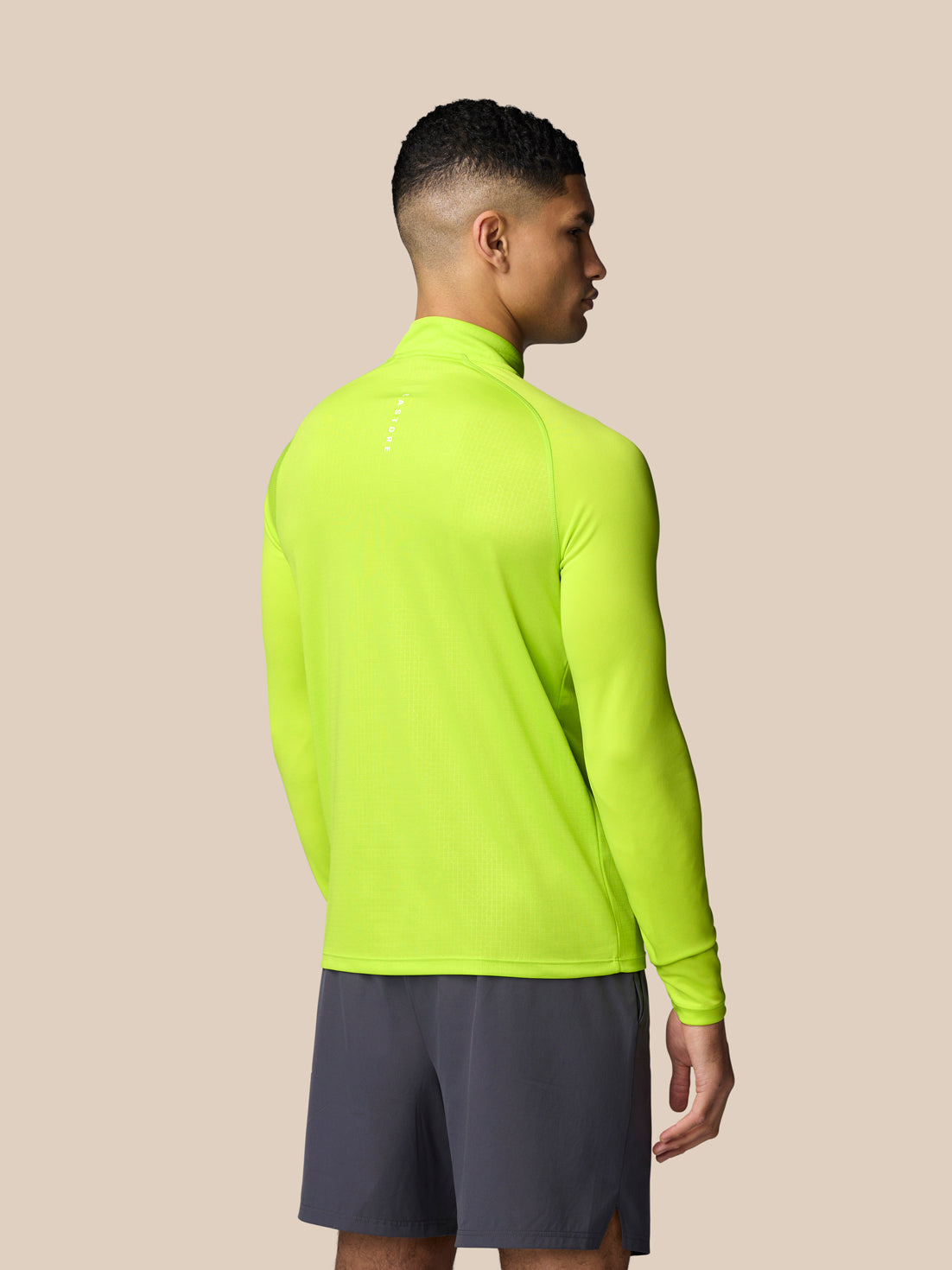 Back view of neon lime Adapt Training 1/4 Zip Top on a male model highlighting the high visibility color.