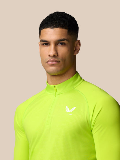 Male model wearing lime green Adapt Training quarter zip top with Castore logo on the left chest