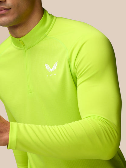Close up of a man in neon lime Adapt Training 1/4 Zip top with front zip and Castore logo on the left chest