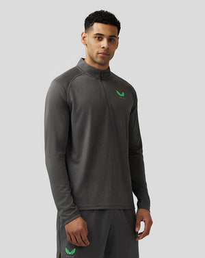 Male model wearing gunmetal Adapt quarter zip top with stand collar subtle geometric pattern and green Castore logo on chest